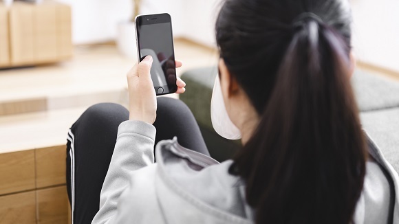 スマホで無料体験を予約する女性