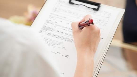 体験申込書に記入する女性